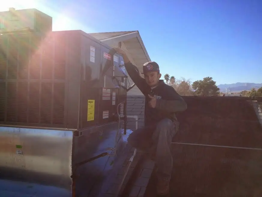 HVAC technician performing AC Tune-Up on a rooftop unit in Boulder Hill